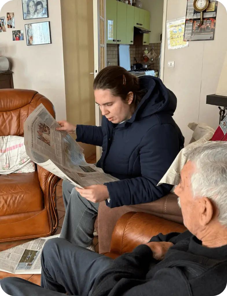 Personne lisant le journal à un résident – Association Le Connetable à Dinan